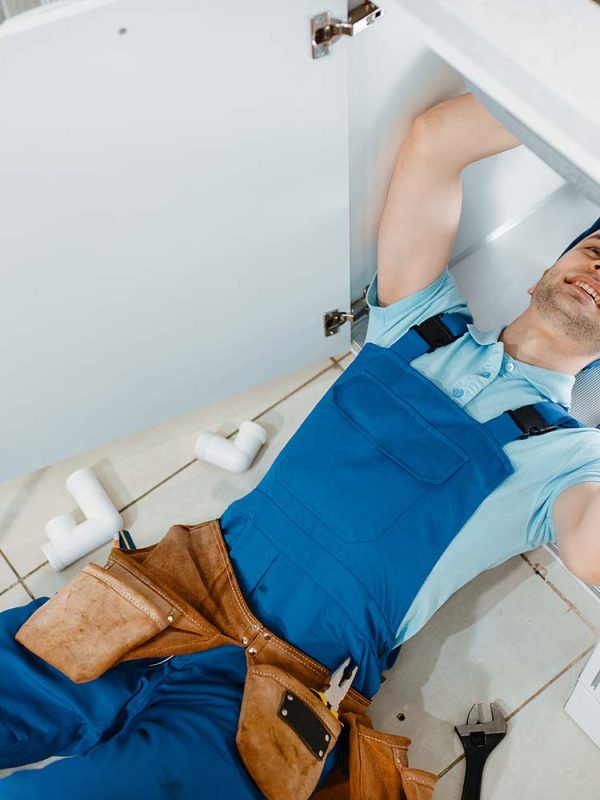 plumber-in-uniform-installing-drain-pipe-top-view-resize.jpg